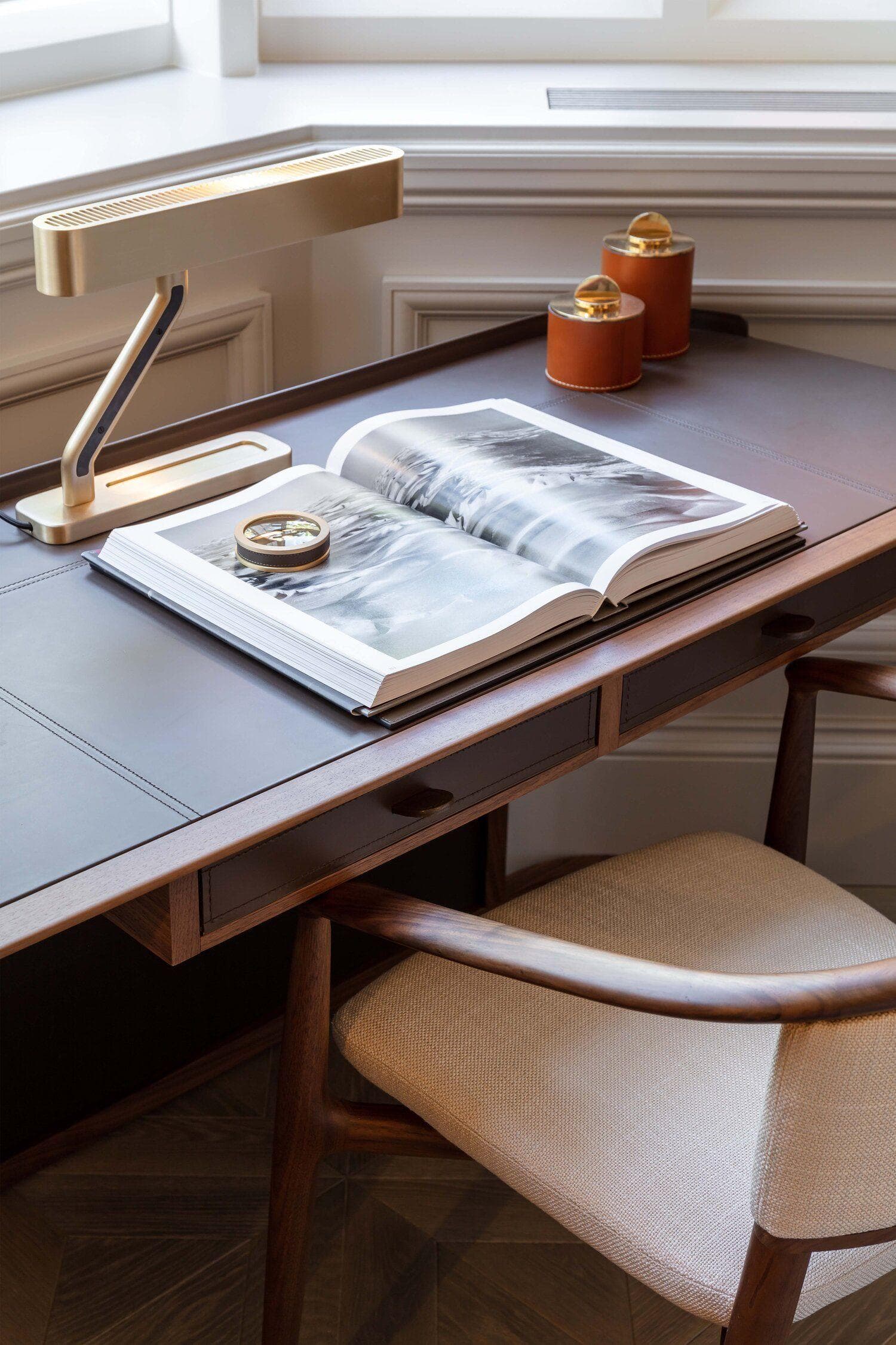 Open book on a premium desk with a reading lamp
